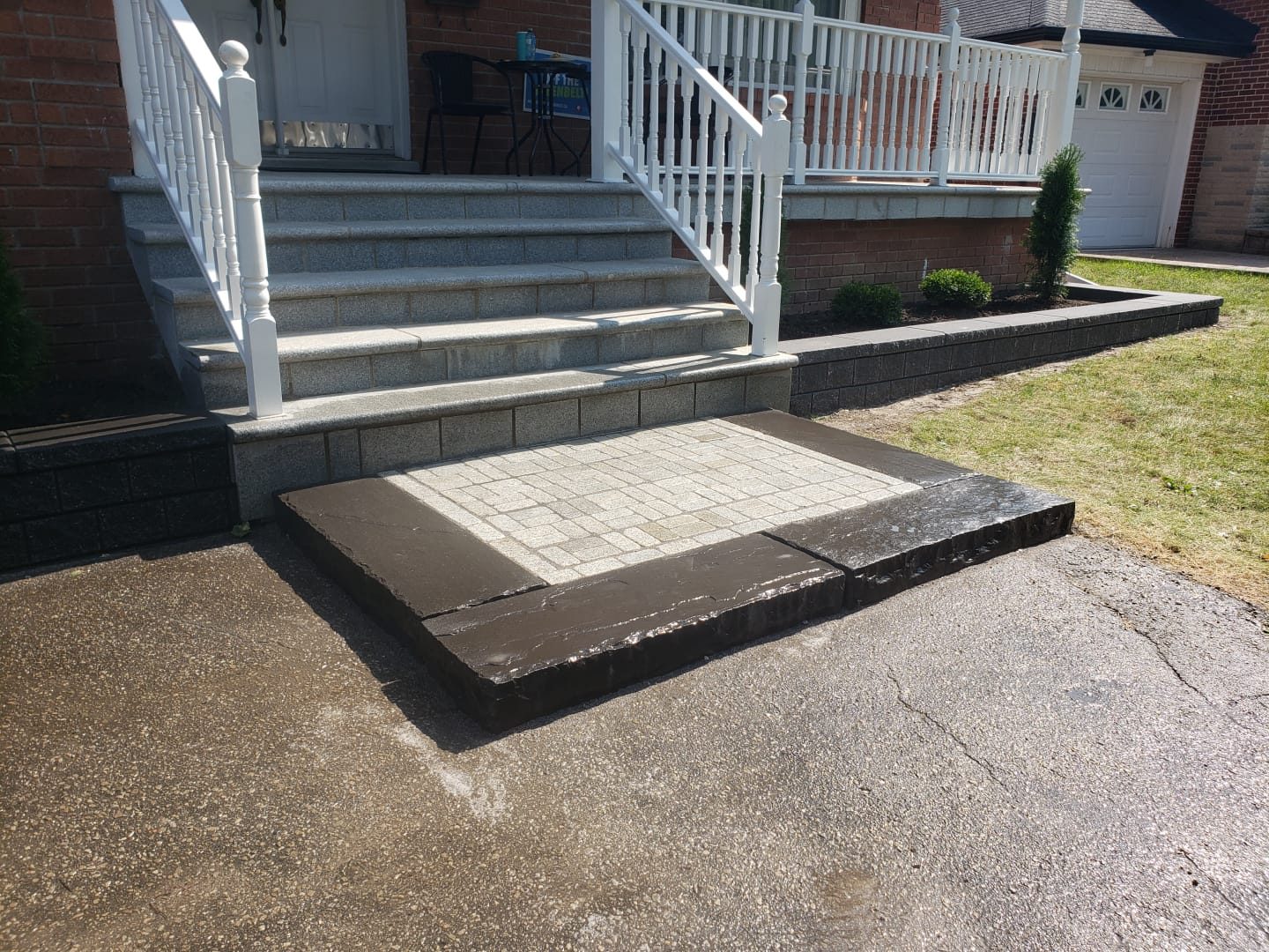 Bordered paver landing beside low garden walls at the porch